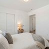 Bright bedroom with plush carpet, sliding-door closet, and neutral decor