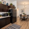 Kitchen with dark wood cabinets and granite countertops opening to a dining area