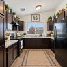 U-shaped kitchen with granite countertops, black appliances, and window over the sink