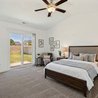 Primary bedroom with ceiling fan and sliding glass door to the private backyard