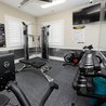 Resident fitness room with cable machine, bench, bike, and dumbbells