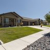 Duplex home with stone facade, front porch, and landscaped lawn
