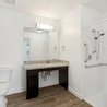 Accessible bathroom with roll-under vanity and walk-in shower with grab bars